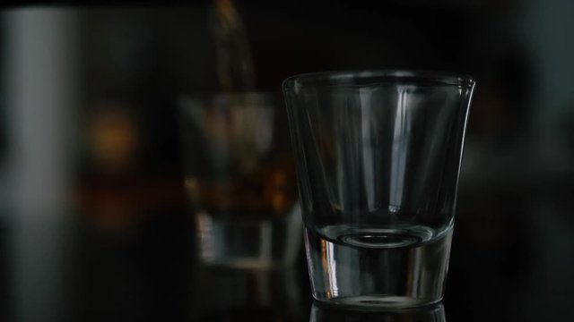 Two shot glasses being poured.
