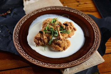 Fried chicken thighs (chicken thighs in batter) with sauce on wooden table