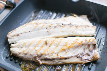 Grilled fish grilled mackerel in a frying pan.