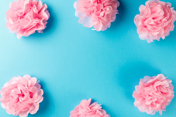 Fototapeta na wymiar Pink flower pattern on blue pastel background. Minimal spring concept. Flat lay. Top view. Copy space