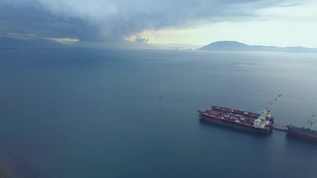 Aerial landscape cloudy sky over sea before storm. Stormy sky and overcast clouds over ships standing in sea port. View from above flying drone.