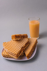 Sweet breakfast with Pieces of waffle cake and a glass of fruit juice.