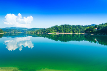 Green lake in Gorski kotar, Lokve, Croatia, with Risnjak mountain in background, reflection in watter 