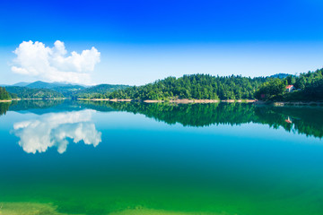 Fototapeta premium Green lake in Gorski kotar, Lokve, Croatia, with Risnjak mountain in background, reflection in watter 