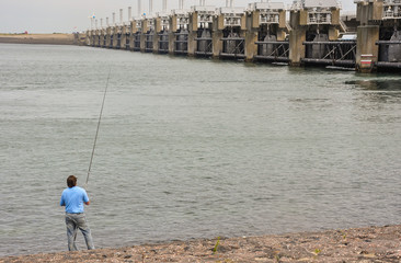 Man fishing in The Great dike of Oosterschelde, Neeltje Jans, Holland, Europe