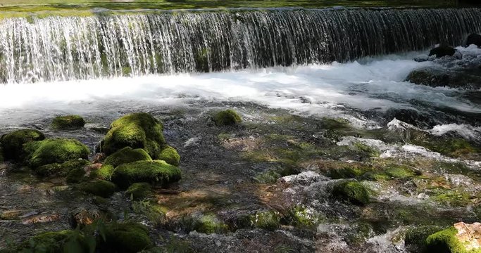 Sunny forest river with magic waterfalls, the Kamnik Bistrica, Slovenia. Dolly slider equipment used.