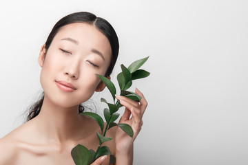 Close up of beauty portrait of beautiful Asian half naked woman with plant, isolated on white background