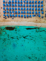 An aerial view of Makronissos beach - Golden sand, turquoise water and blue umbrellas