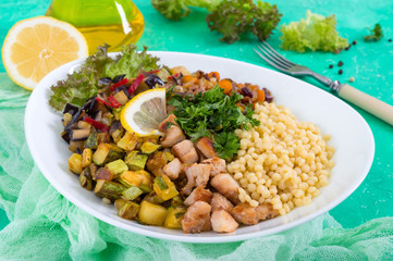 Delicious oriental salad tabbouleh. Couscous with fried vegetables and chicken on a white plate. Traditional Lebanese appetizer.