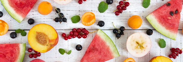 Berry background. Many summer fruits and berries are scattered on a white wooden background. The concept of healthy dietary nutrition. Top view. Flat lay. Banner.