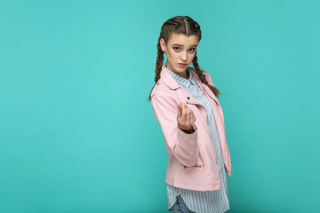 money gesture. portrait of beautiful cute girl standing with makeup and brown pigtail hairstyle in...