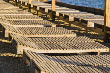 Wooden chaise lounge on the beach on a sunny day.