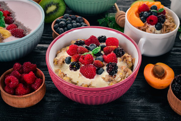 Oatmeal with yogurt and berries. Healthy food. On a wooden background. Top view. Free space for text.