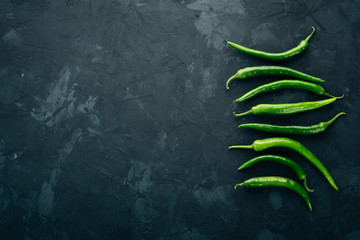 Fresh green chilli. On a black background. Top view. Free space for text.