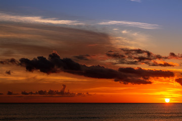 Sunset on the shore of the sea. Sky with dark clouds that anticipate a storm.