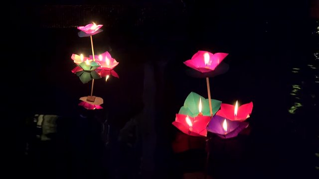 Paper flowers with burning candles float on Tuojiang River at night. Fenghuang, Xiangxi, Hunan, China