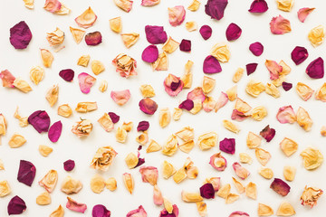 Fototapeta premium Dried rose petals on beige background. Flat lay, top view
