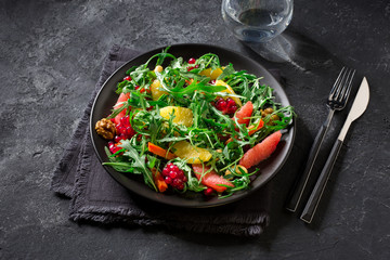 Fruit salad on black plate on dark background