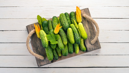 Fresh green cucumbers. Flower cucumber. On a wooden background. Top view. Copy space.
