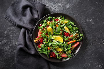 Fruit salad on black plate on dark background