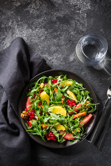 Fruit salad on black plate on dark background