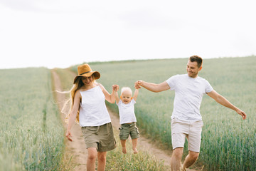 A young family have a fun with their little baby in the field