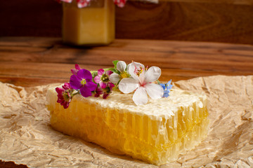 Homemade organic honey in honeycomb from farm apiary on mountains meadows with summer wild flowers