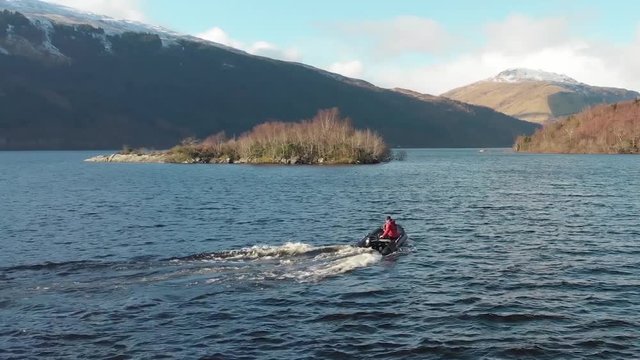 Small Boat Scottish Loch, small outboard engine, Winter/Autumn Snow on Mountains