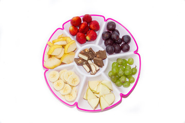 Fruit plate on a white background. Fruit and chocolate. Strawberry, banana, chocolate, grapes, apple, pear.