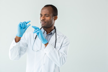 Professional experienced doctor holding a pill