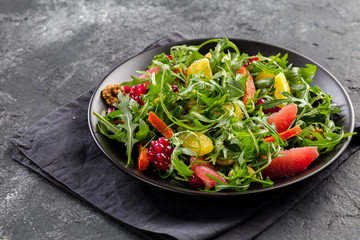 Fruit salad on black plate on dark background