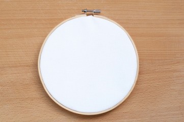 Round wooden hoop with a white cloth.