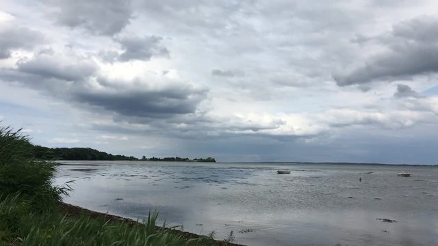 Time lapse from the beach with sky and boats