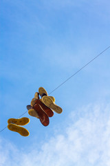 Sneakers hanging on a diagonal clothes line in front of a blue sky