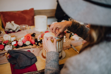 Decorating a cake with macaroons & sweet confectionary together with friends at a party.