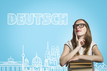 Young girl student with glasses leaning on a pile of books and l