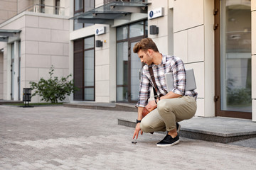 Being awkward. Good looking nice man dropping his keys while being in a hurry