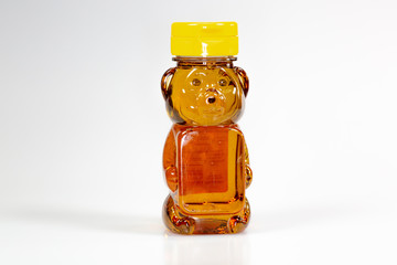 A bear shaped plastic bottle full of honey waiting to be used 