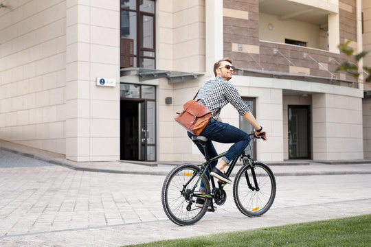 Eco friendly. Happy positive man riding a bicycle while going to work