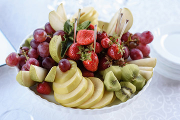 The range of fruit in a white vase.