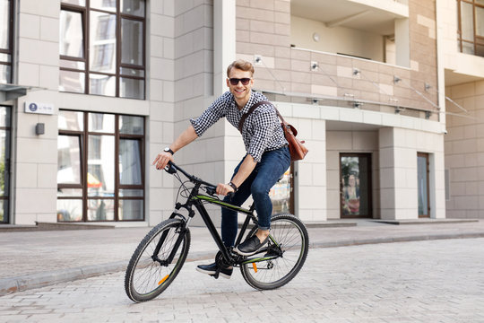 Active lifestyle. Delighted joyful man being in a great mood while enjoying riding a bicycle