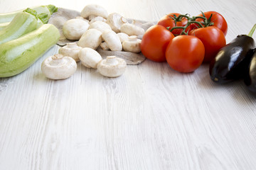 Set of different vegetables on a white wooden background, closeup. Side view. Copy space.