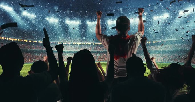 Fans celebrating the success of their favorite sports team, a man is standing with raised hands on the stands of the professional stadium while it's snowing. Stadium is made in 3D and animated.