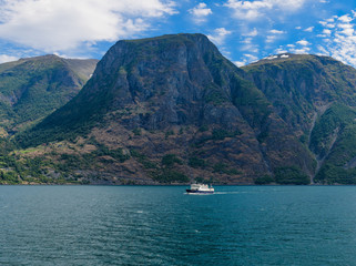 Scandinavian landscape with a walking boat. Neroyfjord offshoot of Sognefjord is the narrowest fjord in Europe. Norway, Europe.