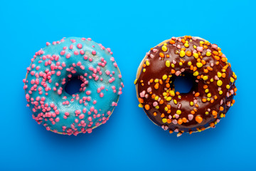 Colorful tasty glazed donuts on a colored background.