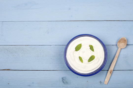 a bowl of yoghurt  over wooden table