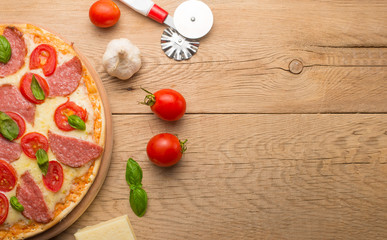 Fresh pizza with tomatoes, cheese and mushrooms on wooden table closeup, Copyspace. Top view.
