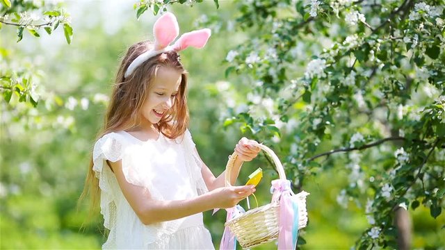 Adorable little girl in blooming apple garden on beautiful spring day