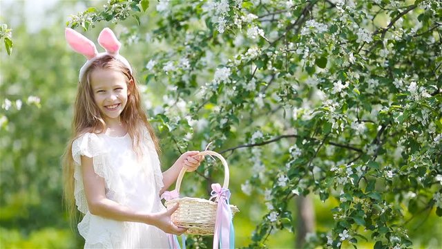 Adorable little girl in blooming apple garden on beautiful spring day