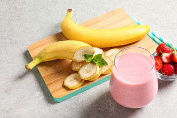 Glass with tasty strawberry smoothie on table